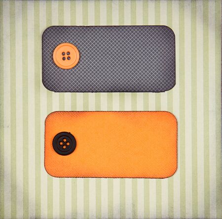 Halloween colored paper tags decorated with buttons on paper background for copy spaceの写真素材
