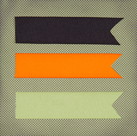 Halloween colored ribbon tags on a scrapbook paper backgroundの写真素材