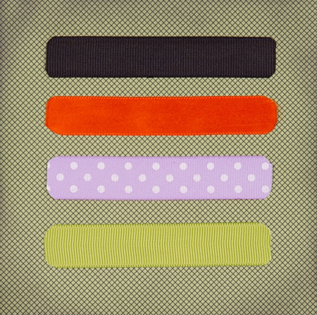 Halloween colored ribbon tags on a scrapbook paper backgroundの写真素材