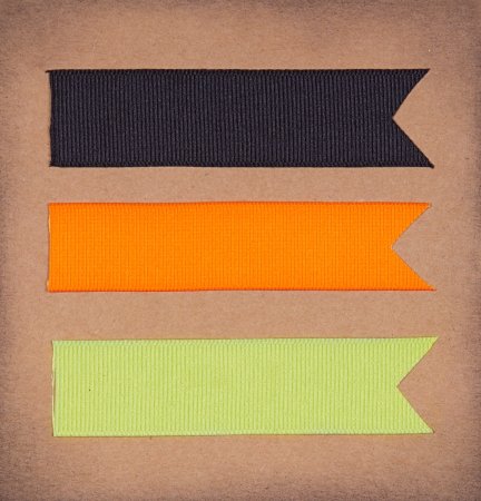 Halloween colored ribbon tags on a scrapbook paper backgroundの写真素材