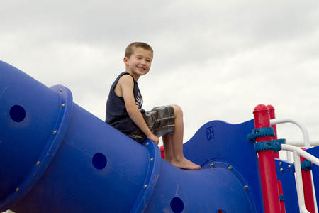 Child climbing on playground equipment outsideの写真素材