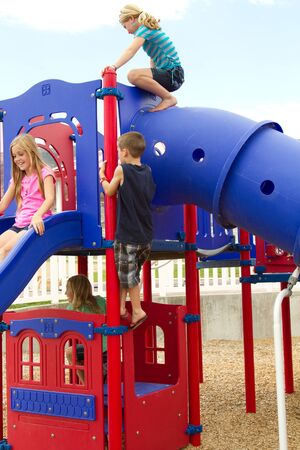 Children or teens playing at playground outsideの写真素材