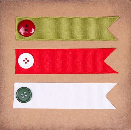 Christmas ribbon tags with buttons on scrabook paper backgroundの写真素材