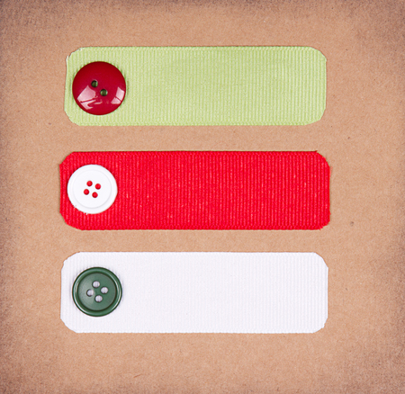 Christmas ribbon tags with buttons on scrabook paper backgroundの写真素材