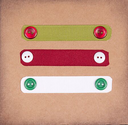 Christmas ribbon tags with buttons on scrabook paper backgroundの写真素材