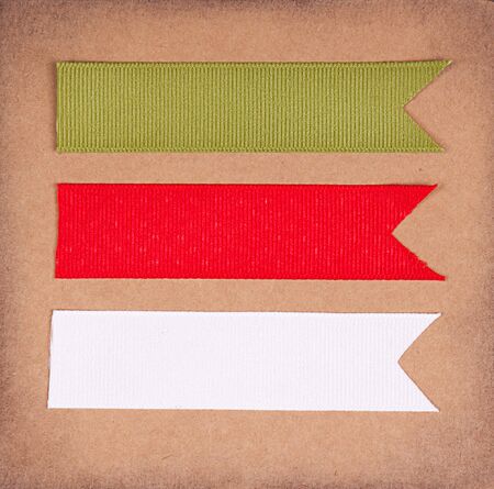Christmas ribbon tags on a scrabook paper backgroundの写真素材