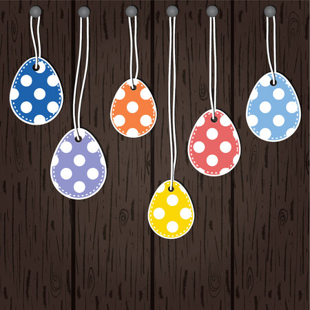 Easter eggs hanging from strings tied to nails on a wooden panel backgroundのイラスト素材