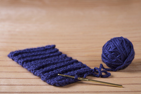 Ball of blue yarn with crochet needle making scarfの写真素材