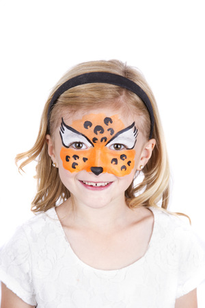 Young girl wearing cheetah carnival face paint isolated on whiteの写真素材