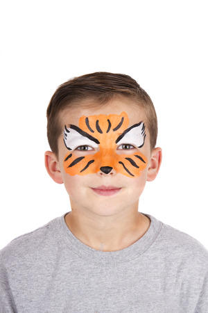 Young boy wearing tiger carnival face paint isolated on whiteの写真素材