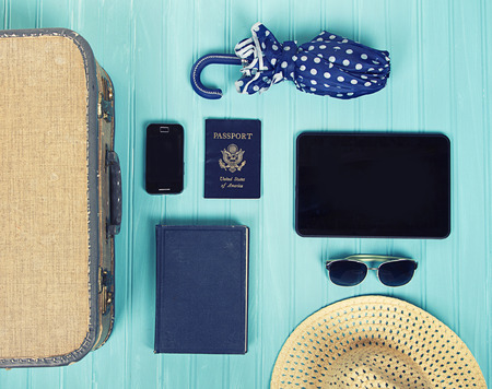 Collection of vacation travel items with a vintage filter on a turquoise backgrouの写真素材
