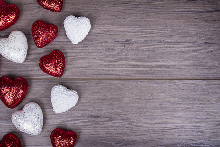 Red and white glitter hearts on wooden backgroundの写真素材