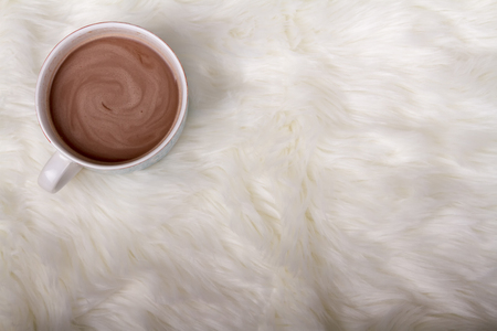 A mug of hot chocolate or cocoa on a faux fur background の写真素材