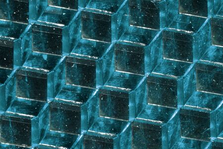 A close up abstract macro photo of a plastic reflector lit with an aqua flash gel