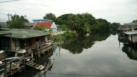 The house is reflected in the water of the Chao Phraya River.の写真素材