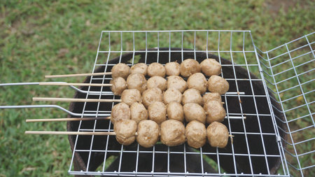 Grilled meatballs on a charcoal grill are prepared for a relaxing day in the dinner menu.の写真素材