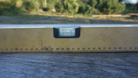 An old water meter is placed on a wooden floor under construction for a garden residence.