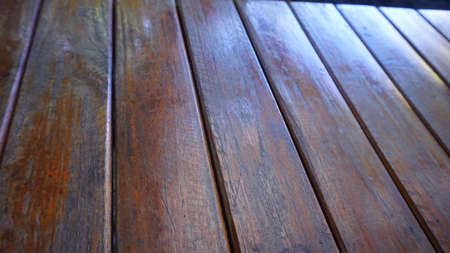 Vertical old brown wooden floor with sunlight shining on vacation seats.