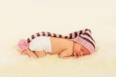 infant sleeping in the white sheepskinの写真素材