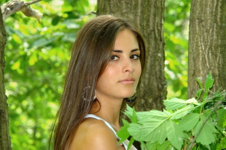 A girl with long hair on the background of the tree                               の写真素材