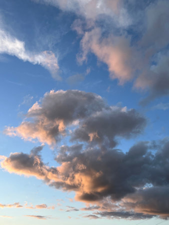 Blue sky with clouds illuminated by sun. Sky at sunset. Natural background.