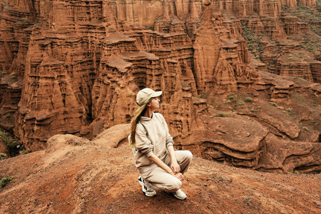 Young girl in light sportswear enjoys the view of the canyon. Kok-Moinok Canyon in Kyrgyzstan....