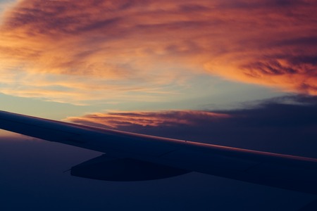 Aerial view scenic sunset sky above clouds with dramatic light. View from airplaneの写真素材