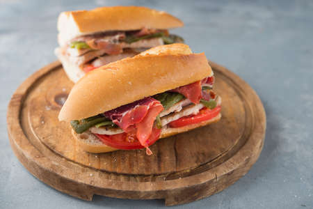 Sandwich Serranito typical in Andalusia with ham, gren pepper and grilled pork loinの写真素材