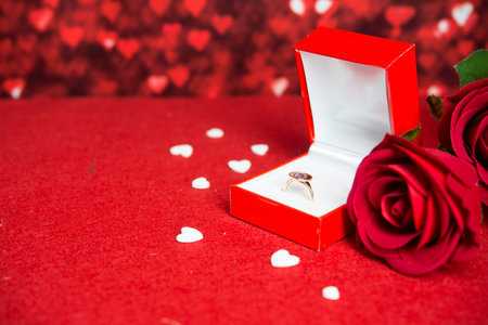 Engagment background (ring, flowers, red background)の写真素材