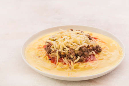 Polenta with tomato, cheese and minceの写真素材