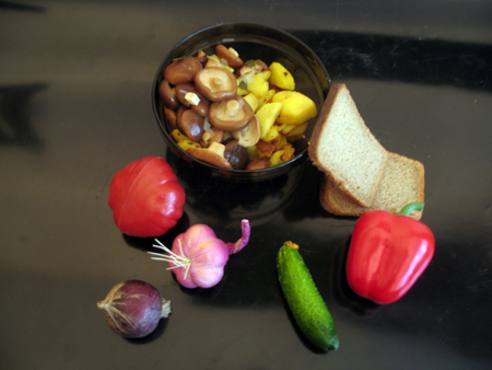 Fried potatoes, marinated mushrooms, black bread, pepper, tomato, onion, garlic, cucumber on a black backgroundの写真素材