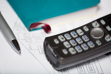 Phone, pen and notebook on the diagramの写真素材