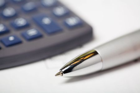 Close up of a calculator, financial figures and pen.の写真素材