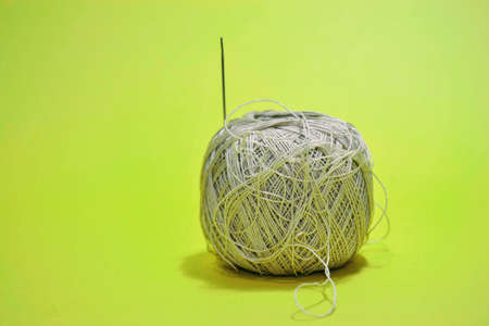 Isolated yellow background for needle. Needle and yellow thread, yarn with isolated background.
