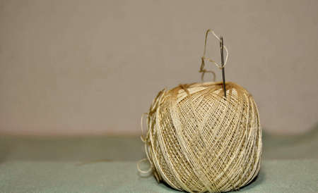 Close up Needle and yellow thread. Details of a thread and it can be observed its winding geometry