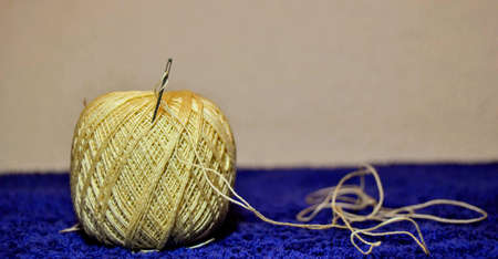Close up Needle and yellow thread. Details of a thread and it can be observed its winding geometryの写真素材