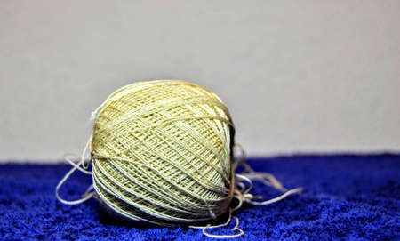 Close up Needle and yellow thread. Details of a thread and it can be observed its winding geometry