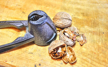 shelled walnut kernels and cracker. Walnut and walnut cracker on the wooden table.