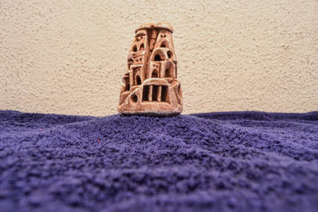 Cappadocia miniature trinket. Nevsehir Turkey. Ancient and miniature fairy chimneys Cappadocia with blue bottom and wall background.の写真素材