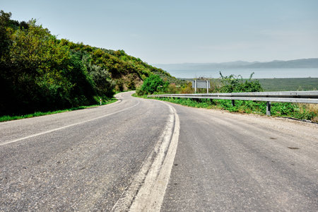 Asphalt road, white line on road, traffic line and lake iznik background in Bursa.