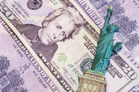 Money background, with a souvenir toy lying on itの写真素材