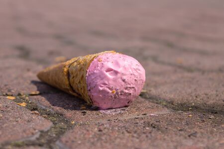 Pink ice cream is lying on the ground