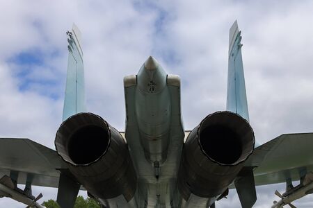 The tail of a military fighter and its two large jet engine nozzlesの写真素材