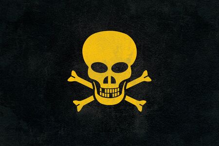 Depicting a yellow skull on a black asphaltの写真素材