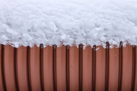 Background, texture of the outer wall of the sewer pipe with snow on top
