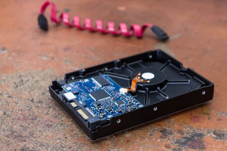 Computer hard drive lies on a table in an electronics repair shop