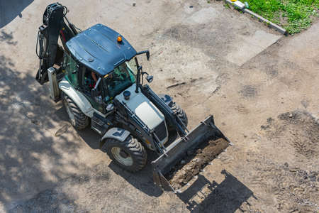 Tractor with bucket for excavation work during road construction