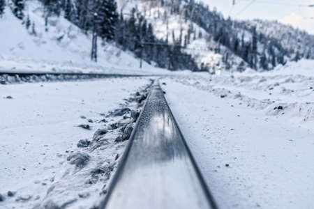 Railroad rails close up on the background of snowy mountainsの写真素材