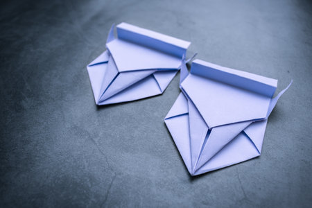Origami, two paper cars, compete against each other on a makeshift race track. Hobby to fold various figures out of paper and create various scenesの写真素材
