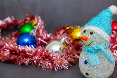 Toy snowman on the background of Christmas decorations as a design element